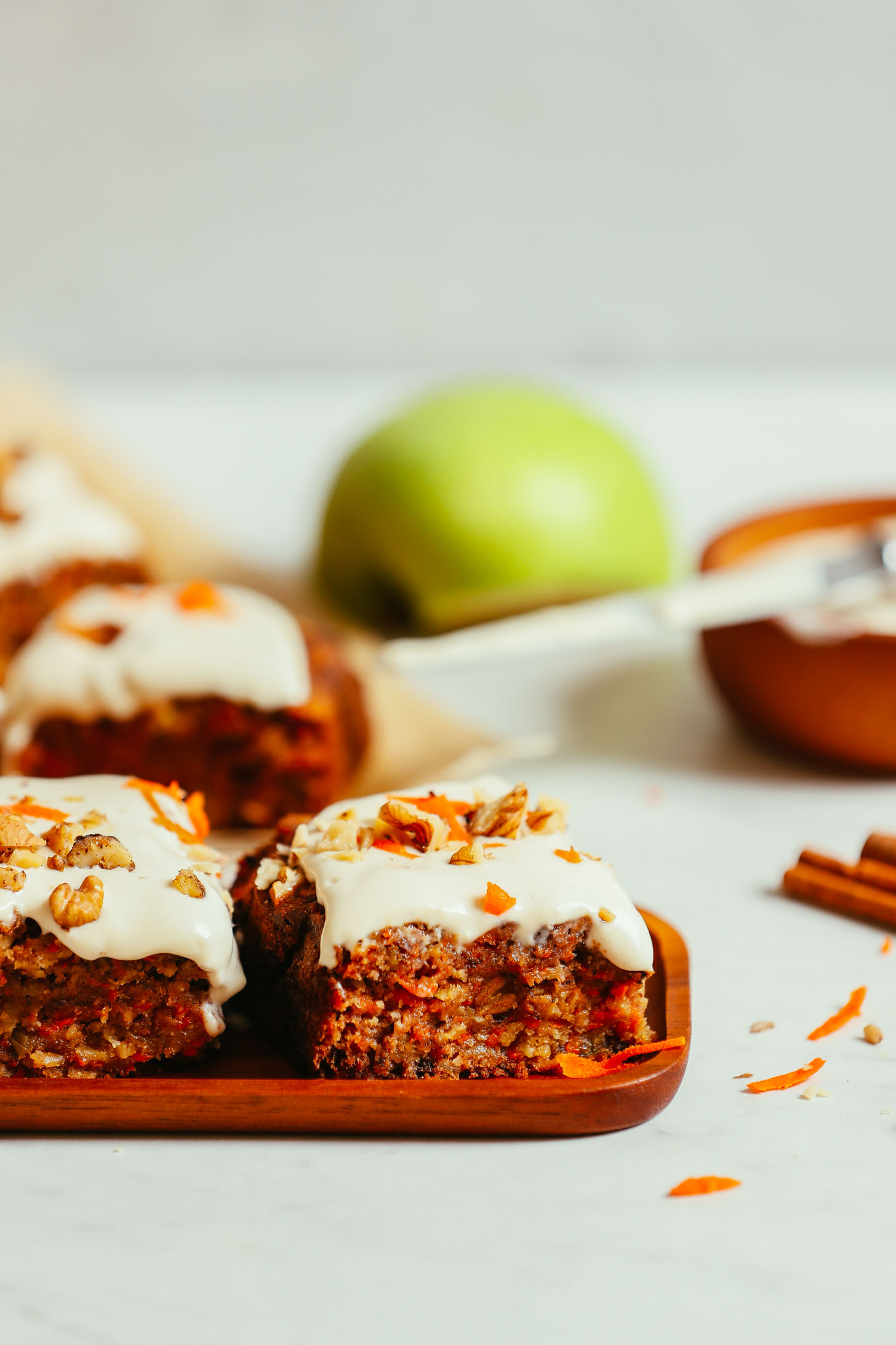 Wood tray and parchment paper with slices of gluten-free vegan Carrot Apple Snack Cake