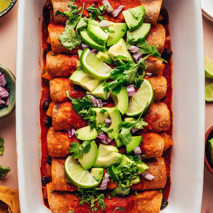 Overhead shot of a baking dish of butternut squash and black bean enchiladas