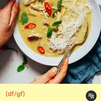 Spoon in a bowl of Thai-Inspired Chicken Noodle Soup