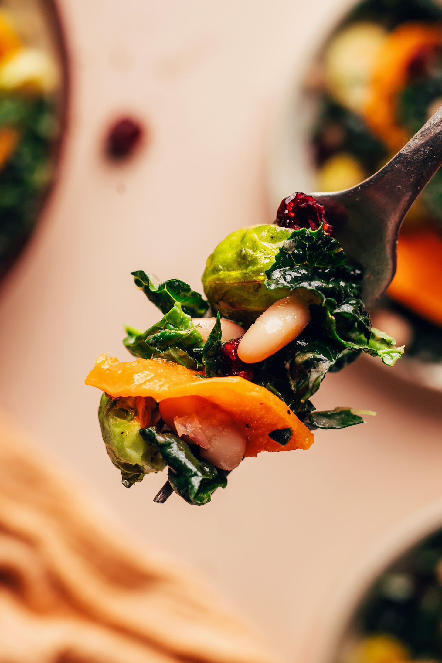 Close up photo of a fork speared with a bite of salad