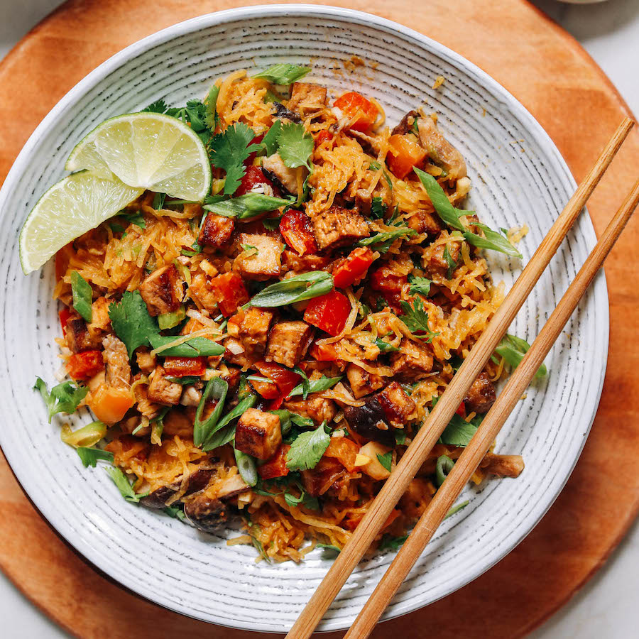 Chopsticks resting on a bowl of spaghetti squash stir fry