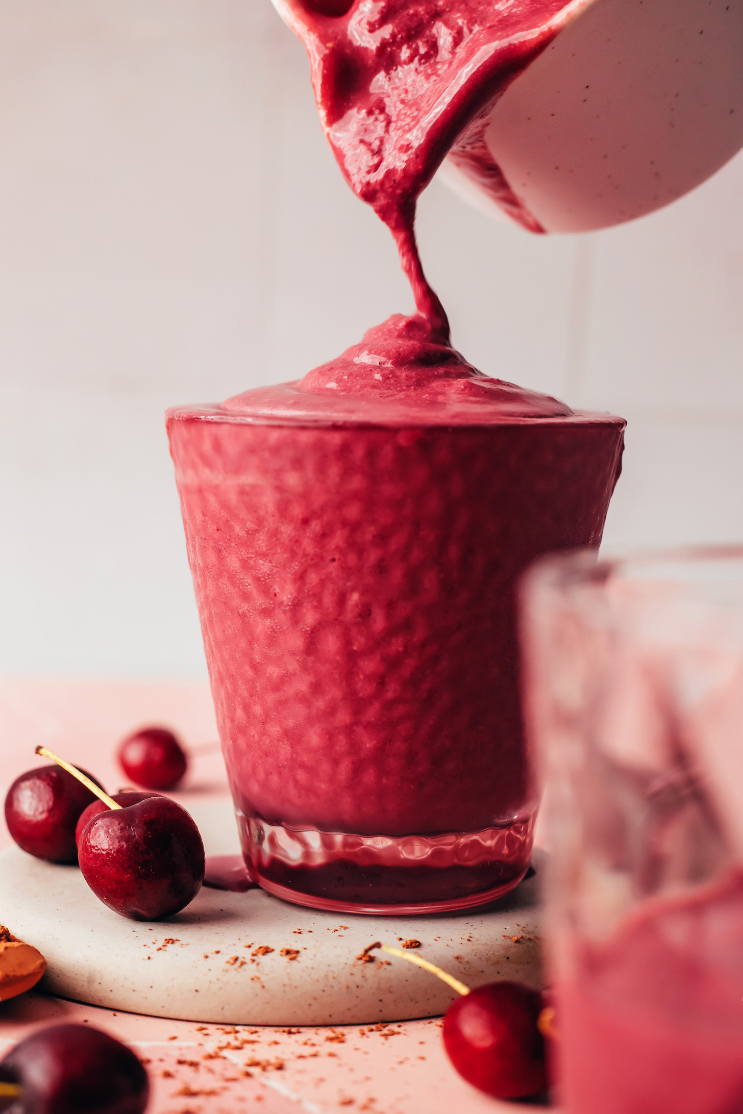 Pouring a chocolate cherry protein shake into a glass