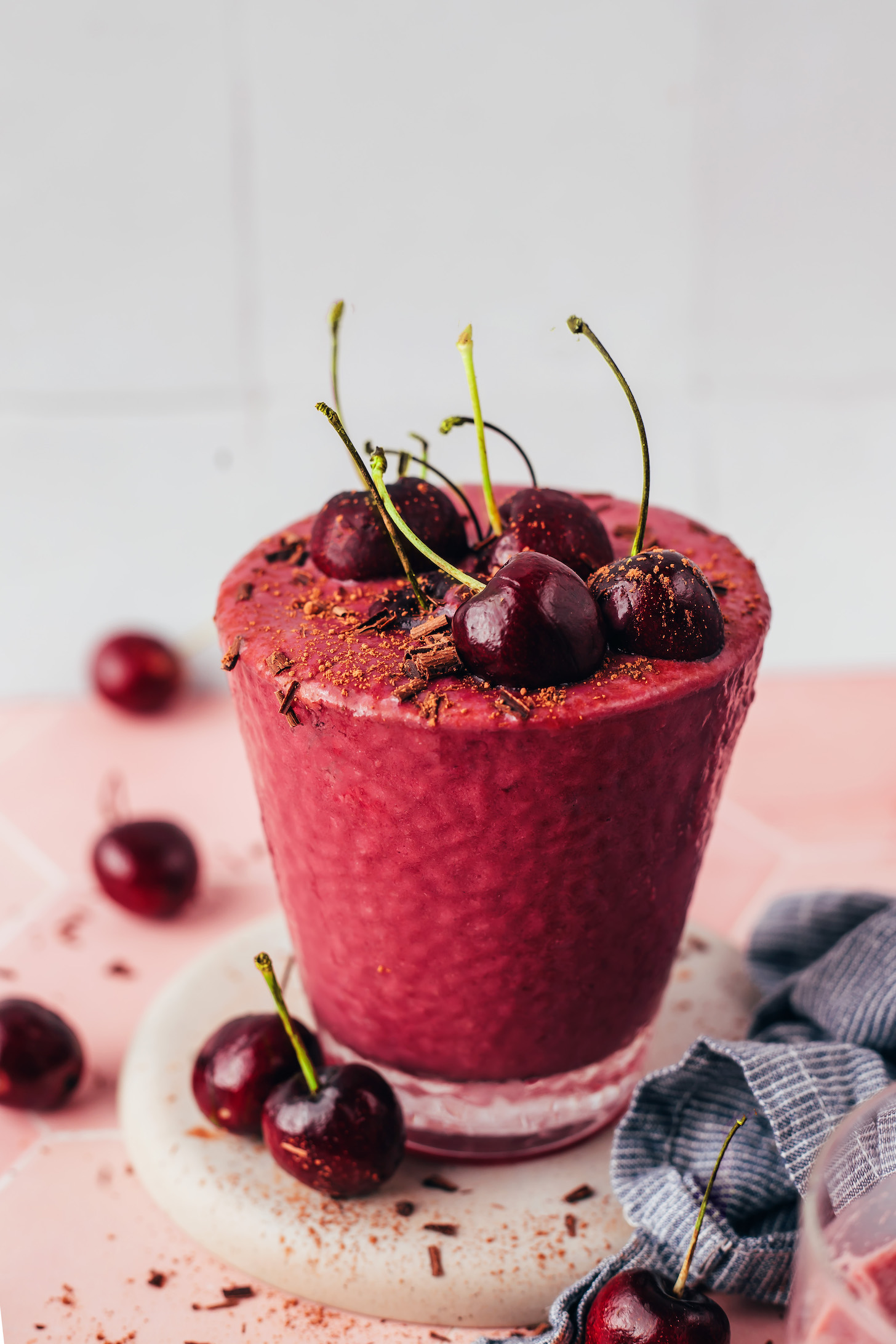 Glass of our chocolate cherry protein shake topped with cherries and shaved dark chocolate